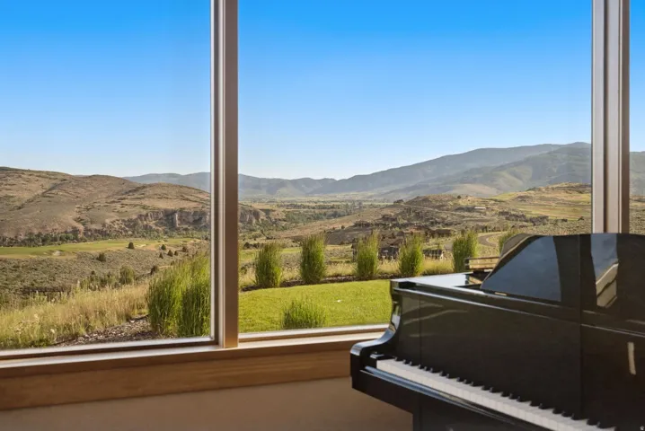 Expansive window framing panoramic mountain and valley scenery