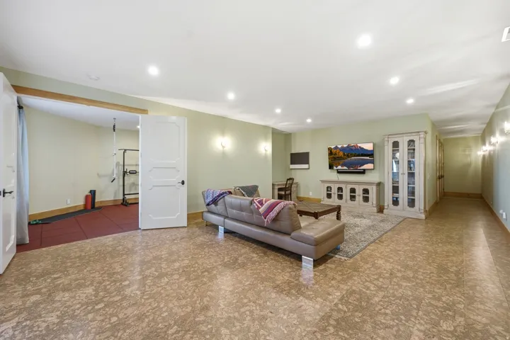 Spacious room featuring patterned flooring, recessed lighting, and soft green wall tones