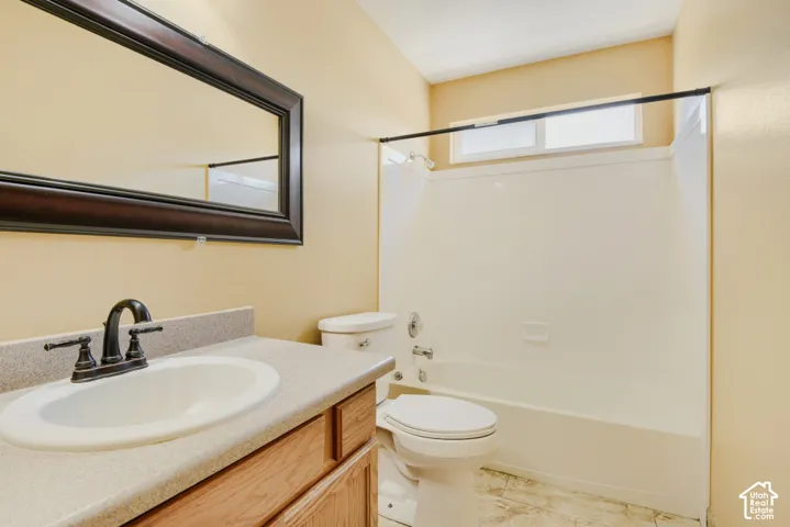 Bathroom featuring a single vanity with an integrated sink, dark bronze faucet, and a framed wall mirror