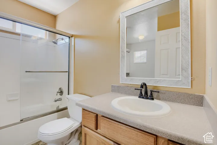 Bathroom vanity featuring a white oval sink set into a speckled countertop