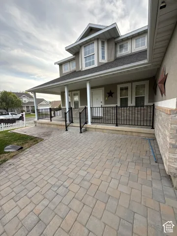 Stucco exterior with stone veneer accents, multi-pane windows, and a covered porch