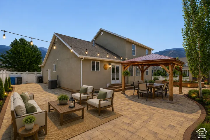Expansive paved patio featuring a built-in wooden gazebo with a metal roof