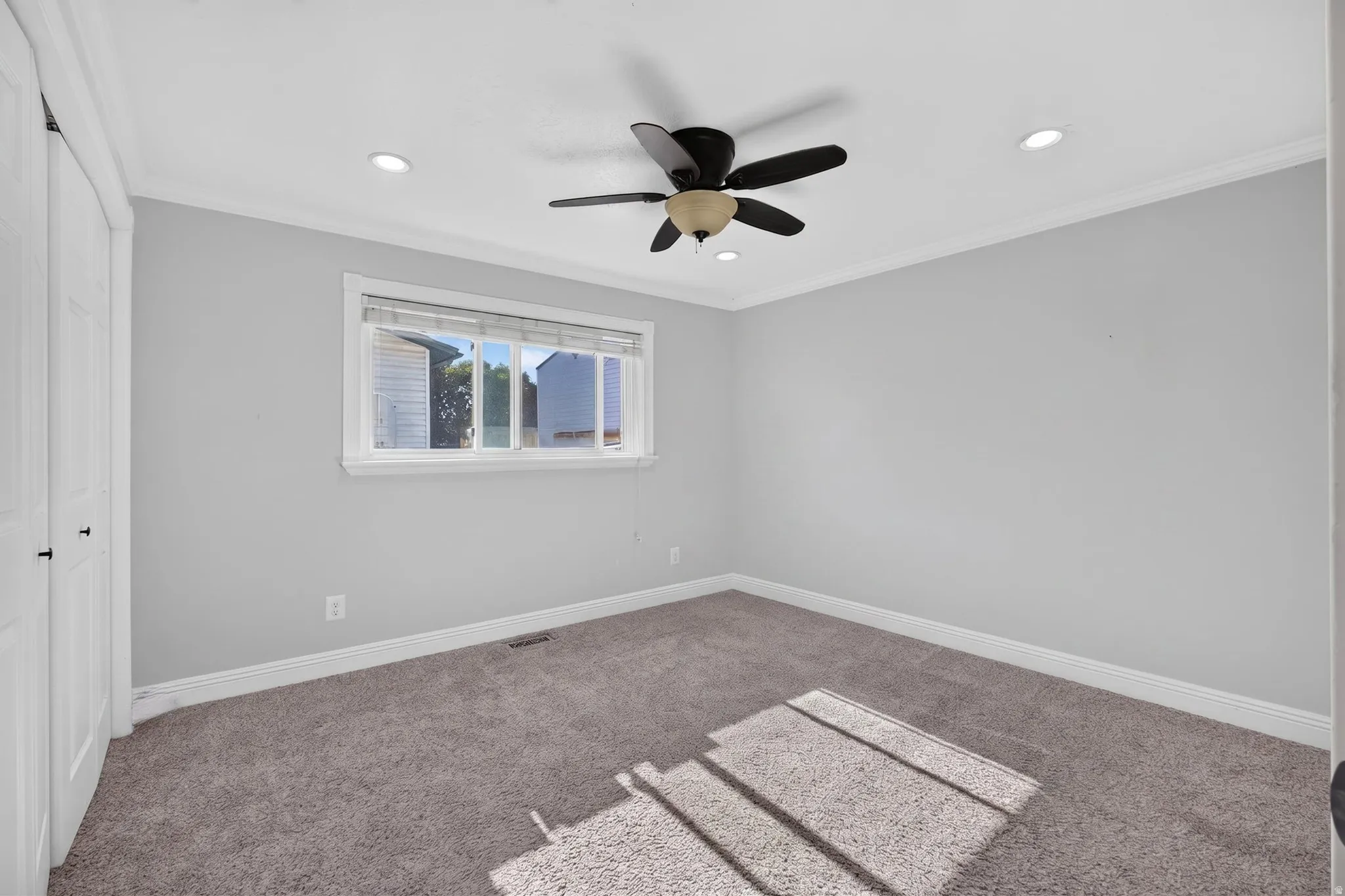 Neutral gray walls with white trim, recessed lighting, and a ceiling fan