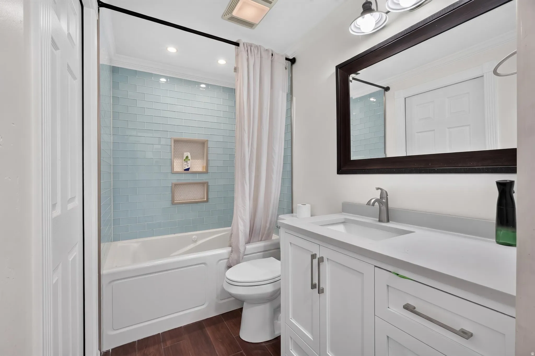 Bathroom with subway tile shower surround, integrated tub, and dual shower niches