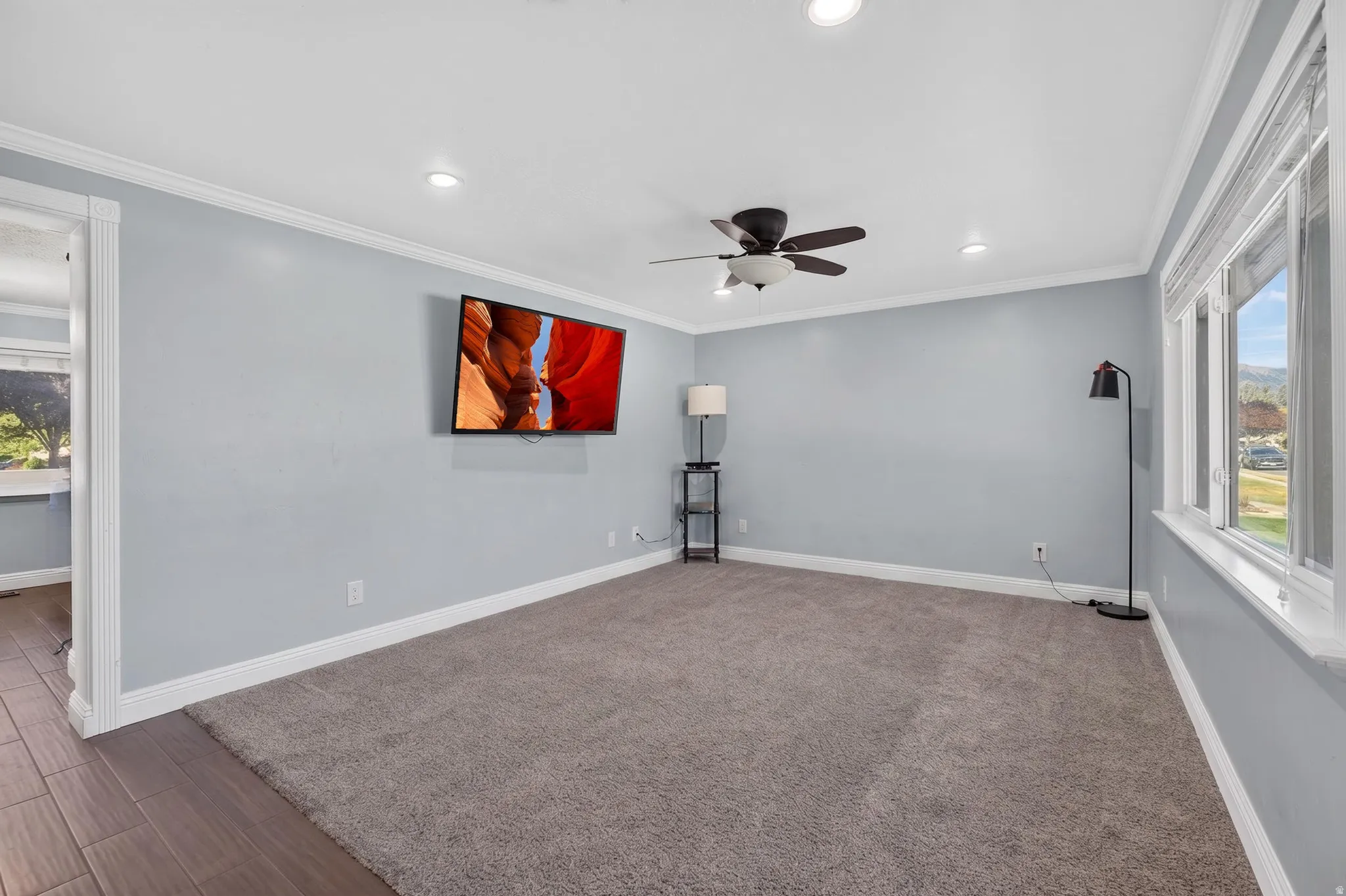 Carpeted room featuring light blue walls, white trim, recessed lighting, and a ceiling fan