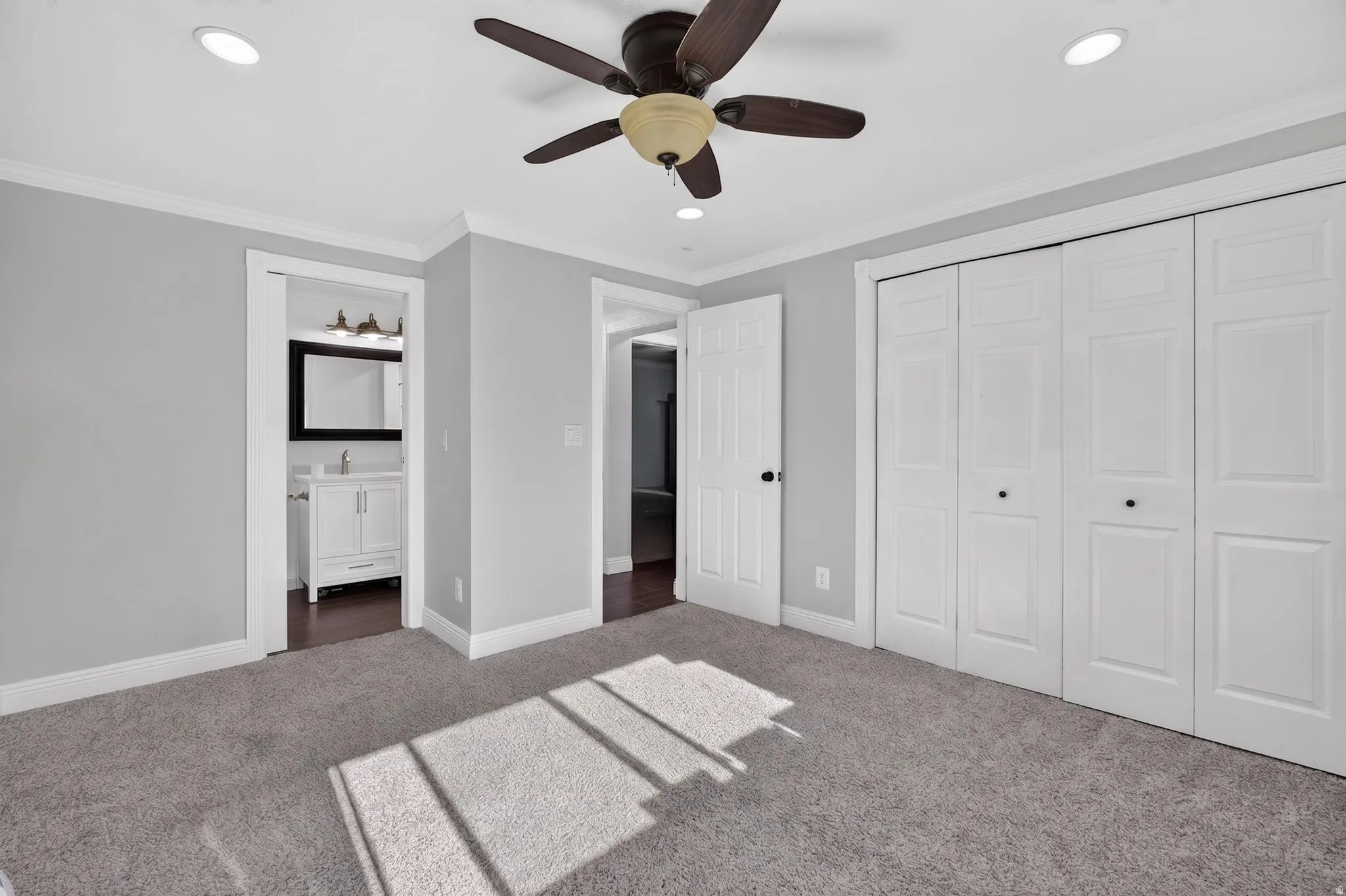 Carpeted room featuring a ceiling fan with light fixture, recessed lighting, and white bi-fold closet doors