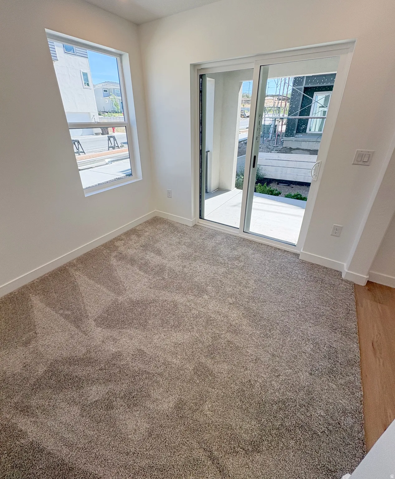Neutral tone carpet flooring with baseboard trim
