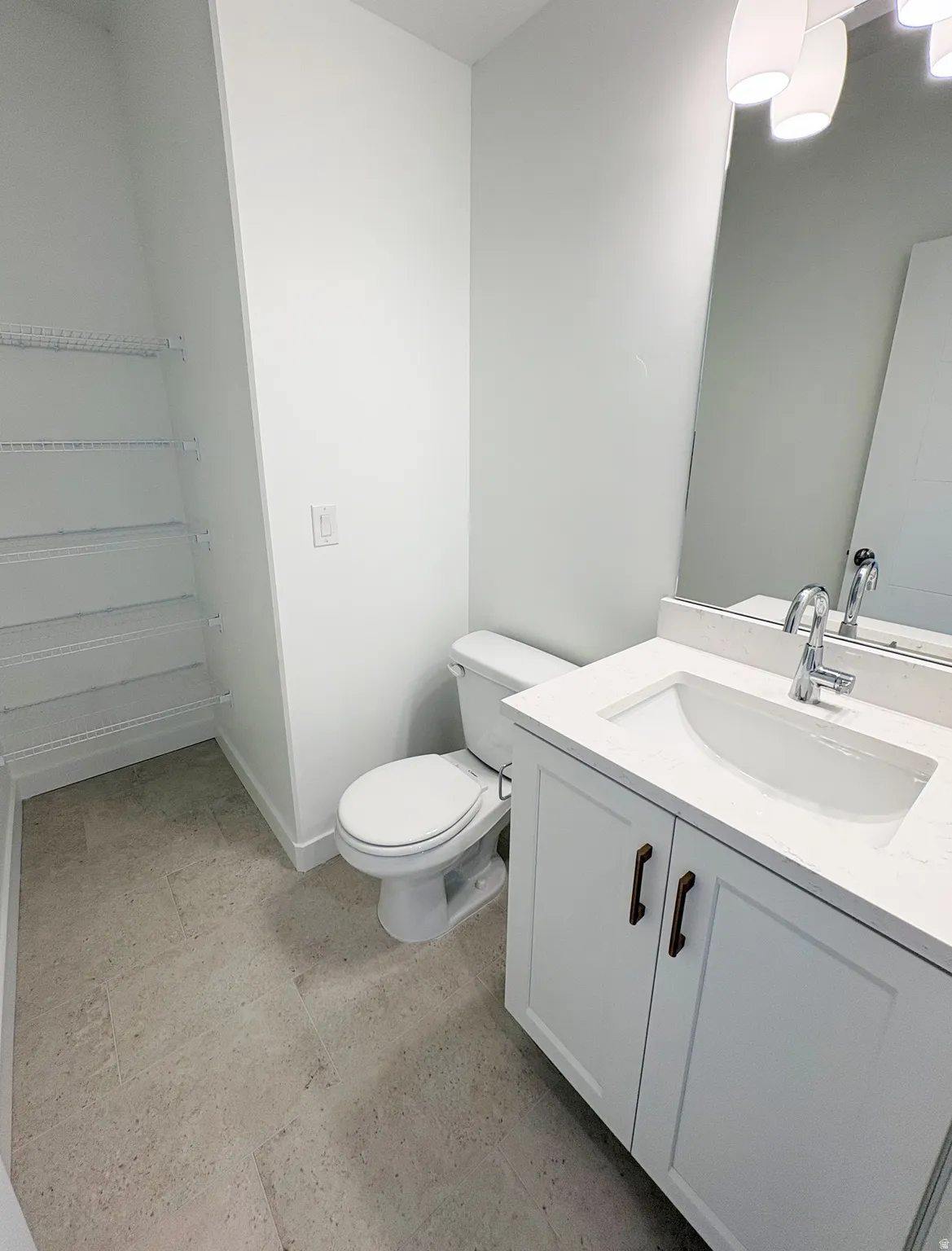 Bathroom featuring a white vanity with bronze hardware, integrated sink, and stone-finish countertop