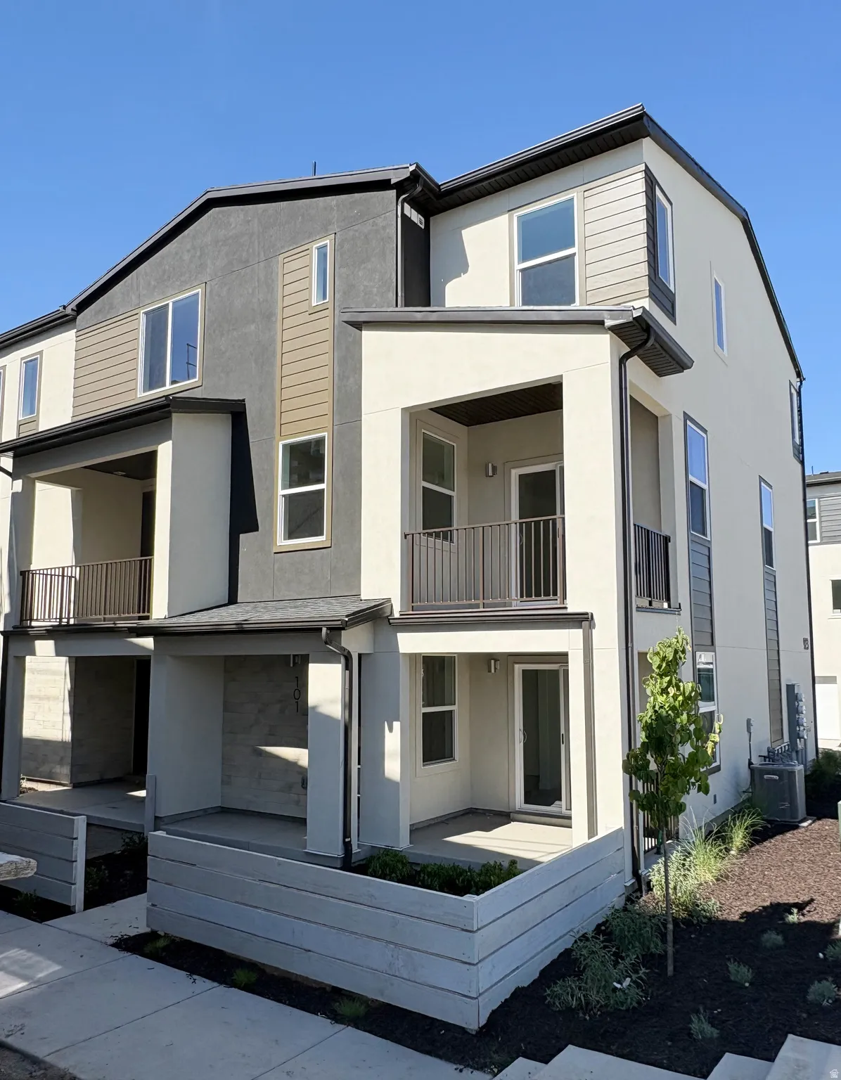 Multi-level townhome exterior featuring contemporary design with varied siding textures