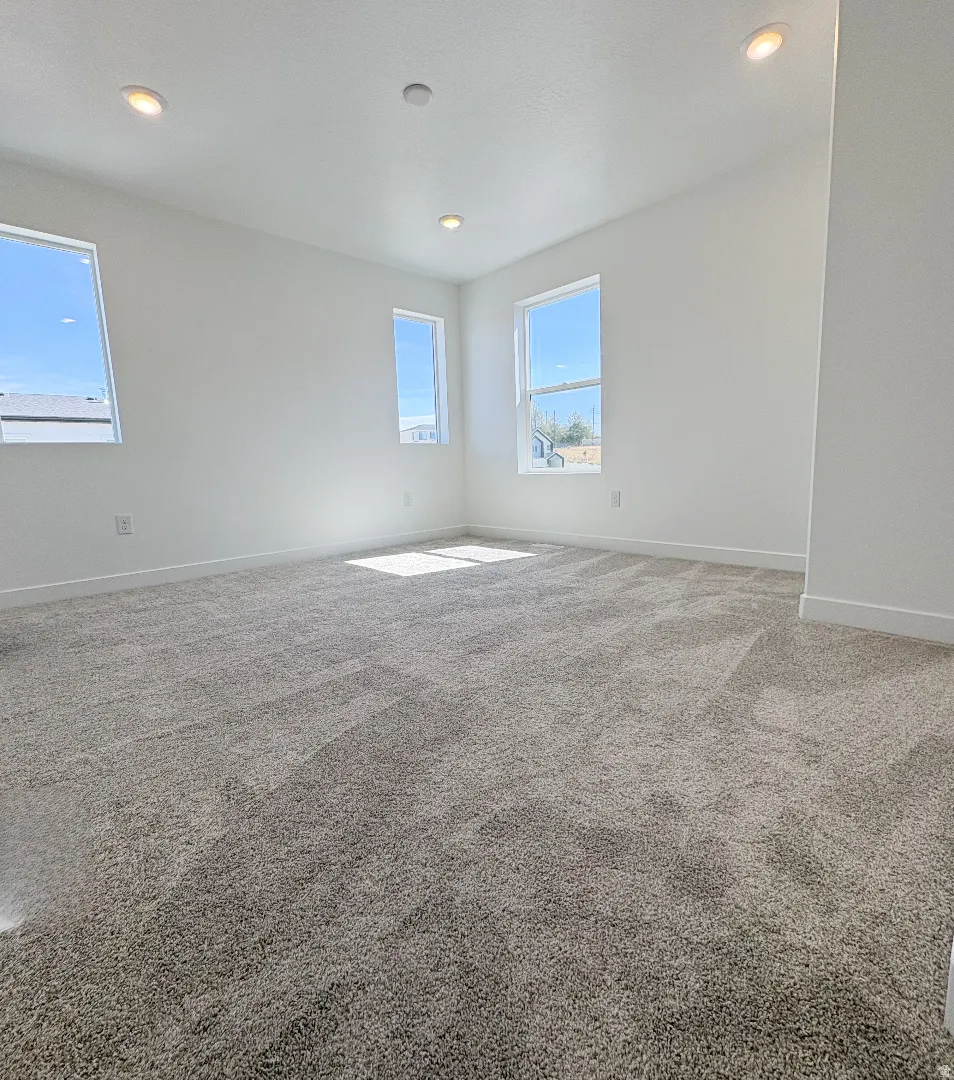 Spacious room featuring neutral carpeting and white walls