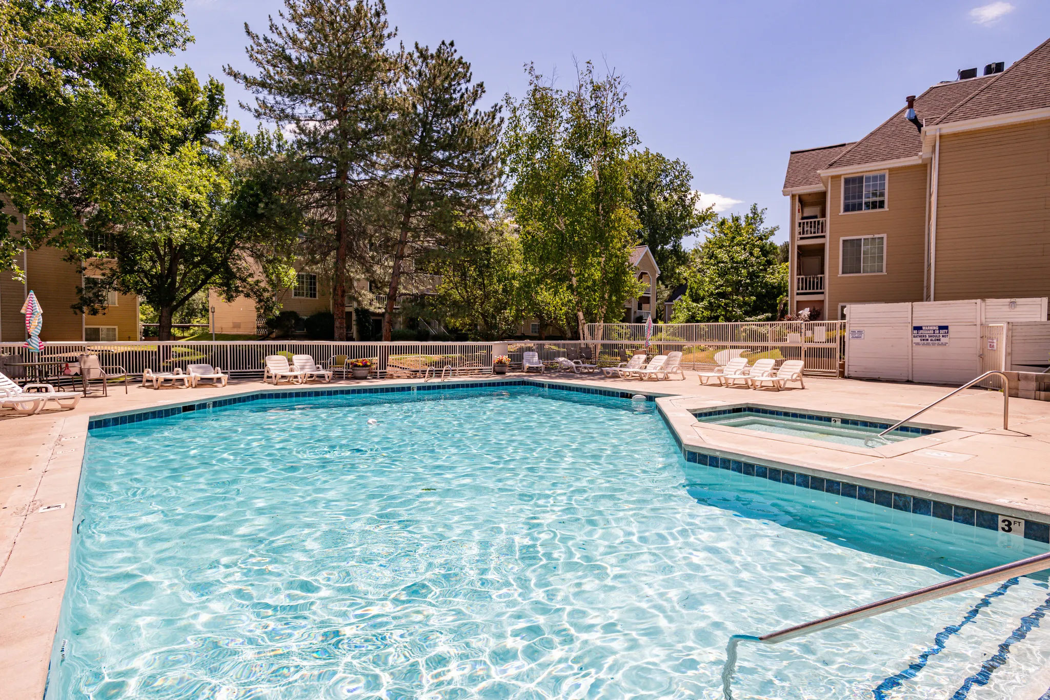 Outdoor swimming pool with integrated spa and concrete surround