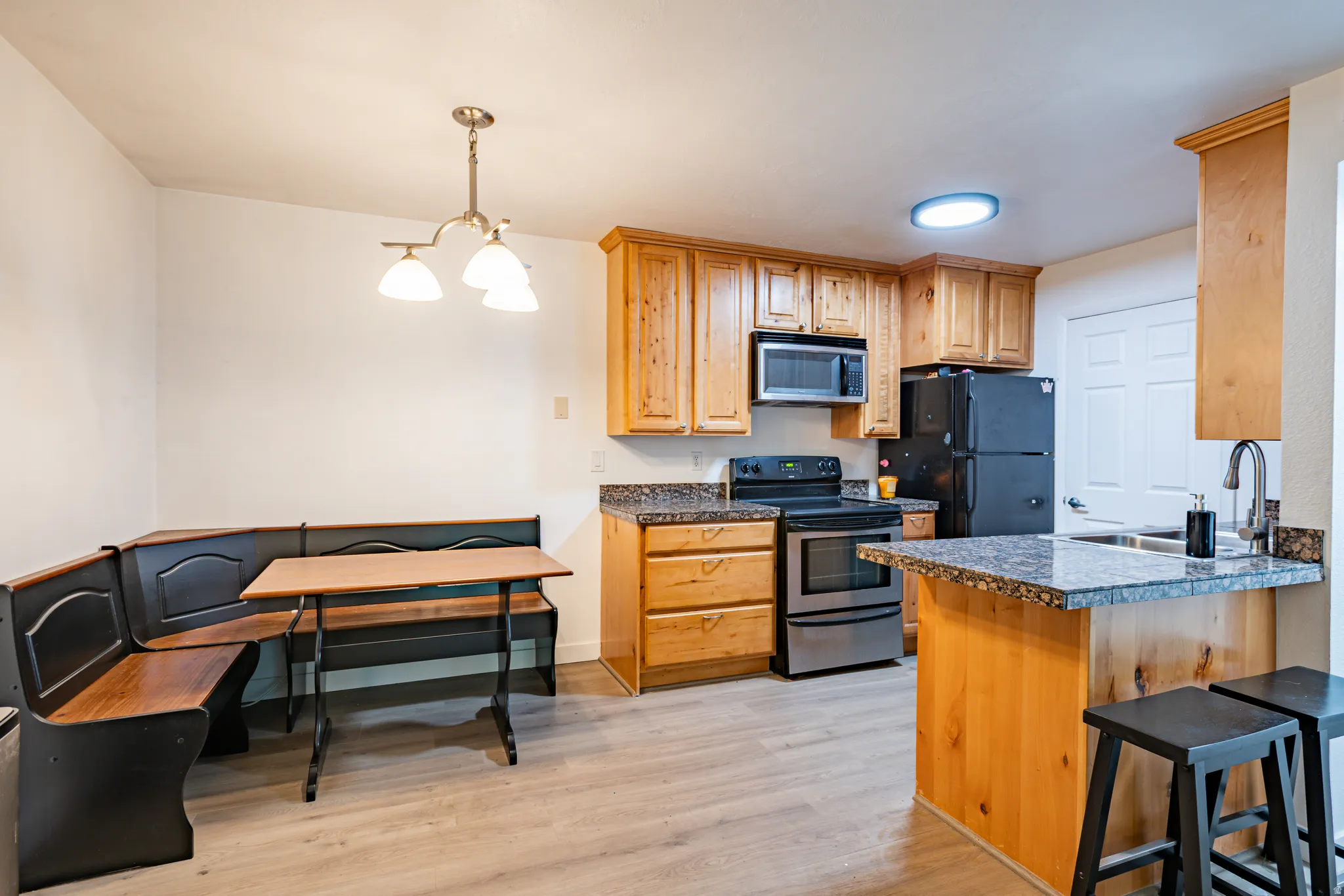 Kitchen featuring wood-finish cabinetry and gray granite-finish countertops