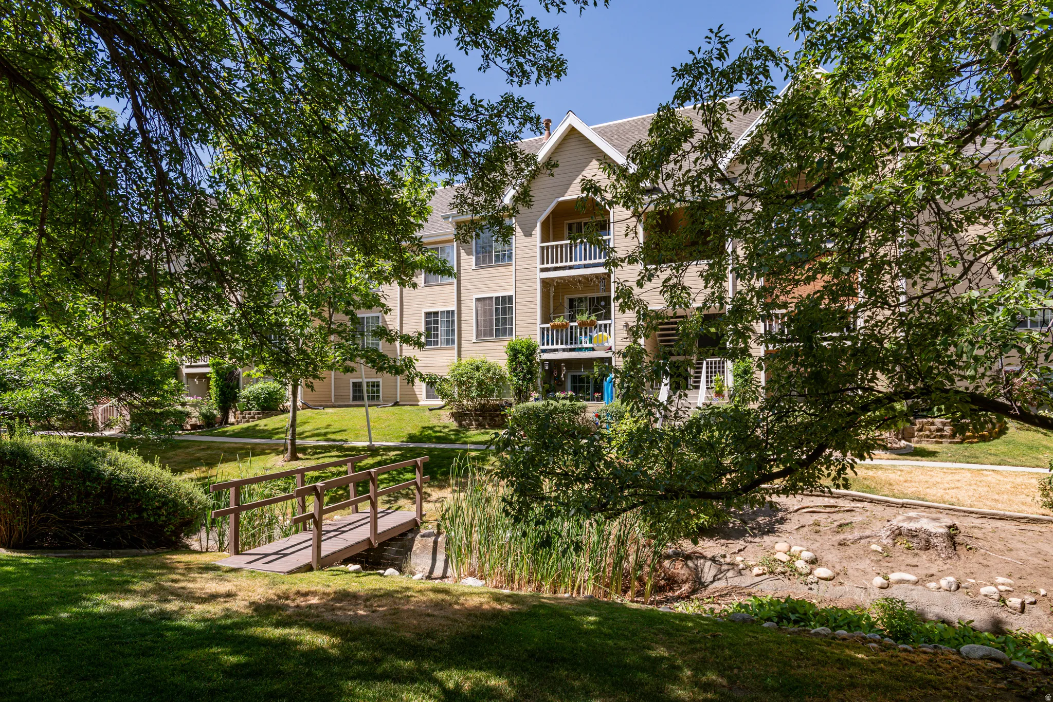Exterior multi-story building featuring multiple balconies, dormer windows, and a neutral-toned facade