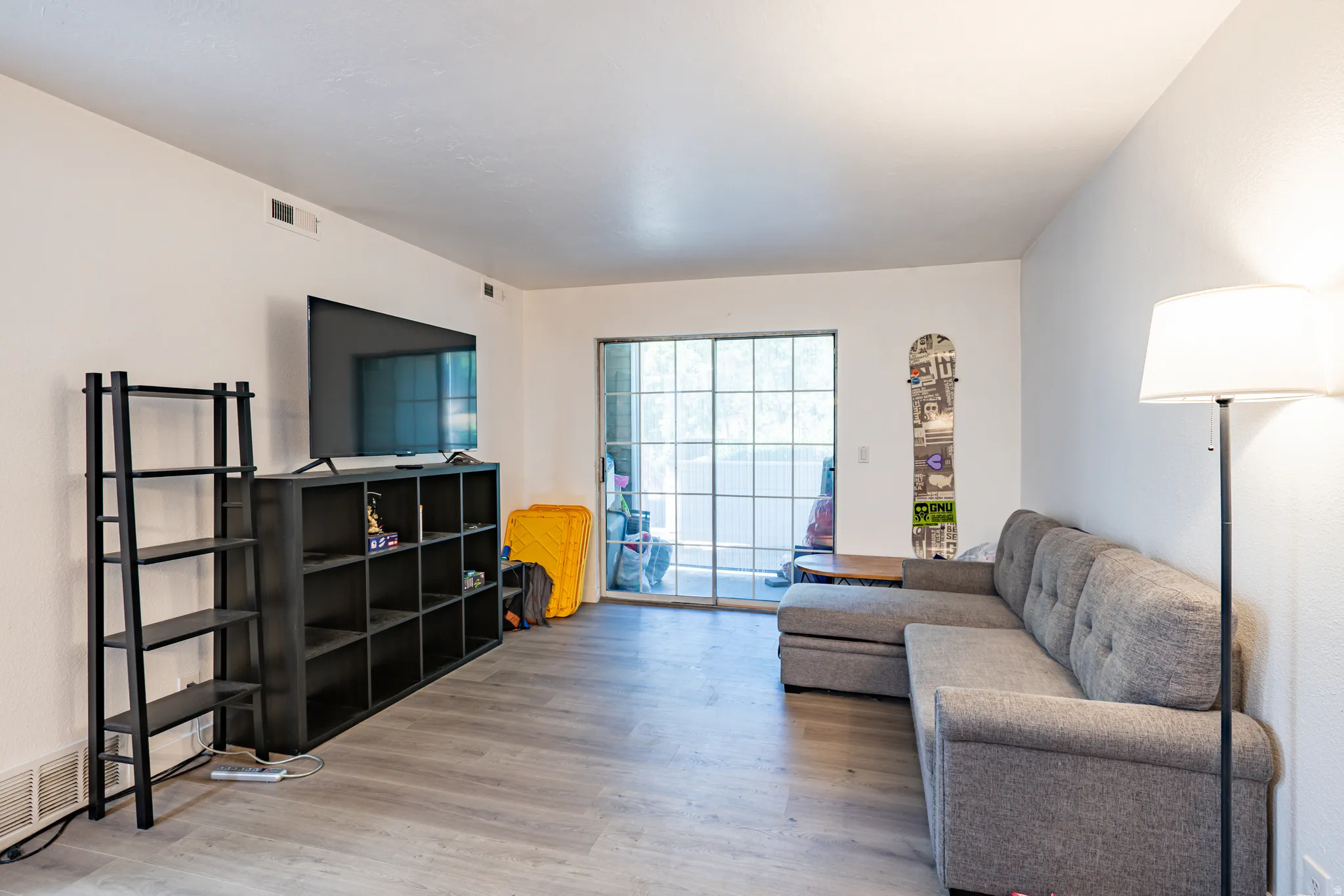 Bright living space featuring wood-finish flooring and white walls