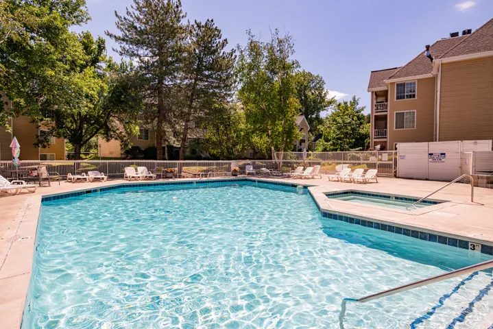 Outdoor swimming pool with integrated spa and concrete surround