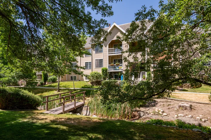 Exterior multi-story building featuring multiple balconies, dormer windows, and a neutral-toned facade