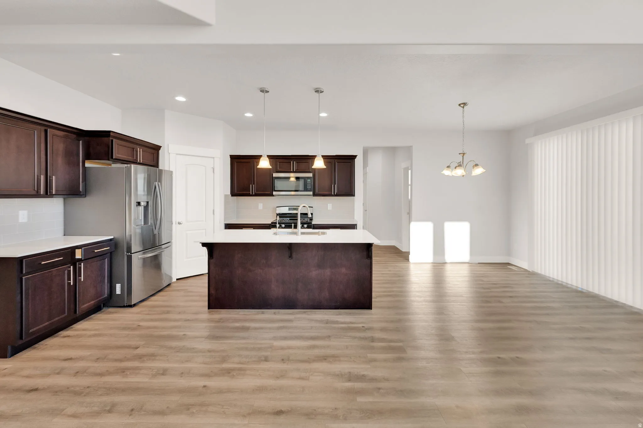 Spacious open-concept area featuring wood-finish flooring