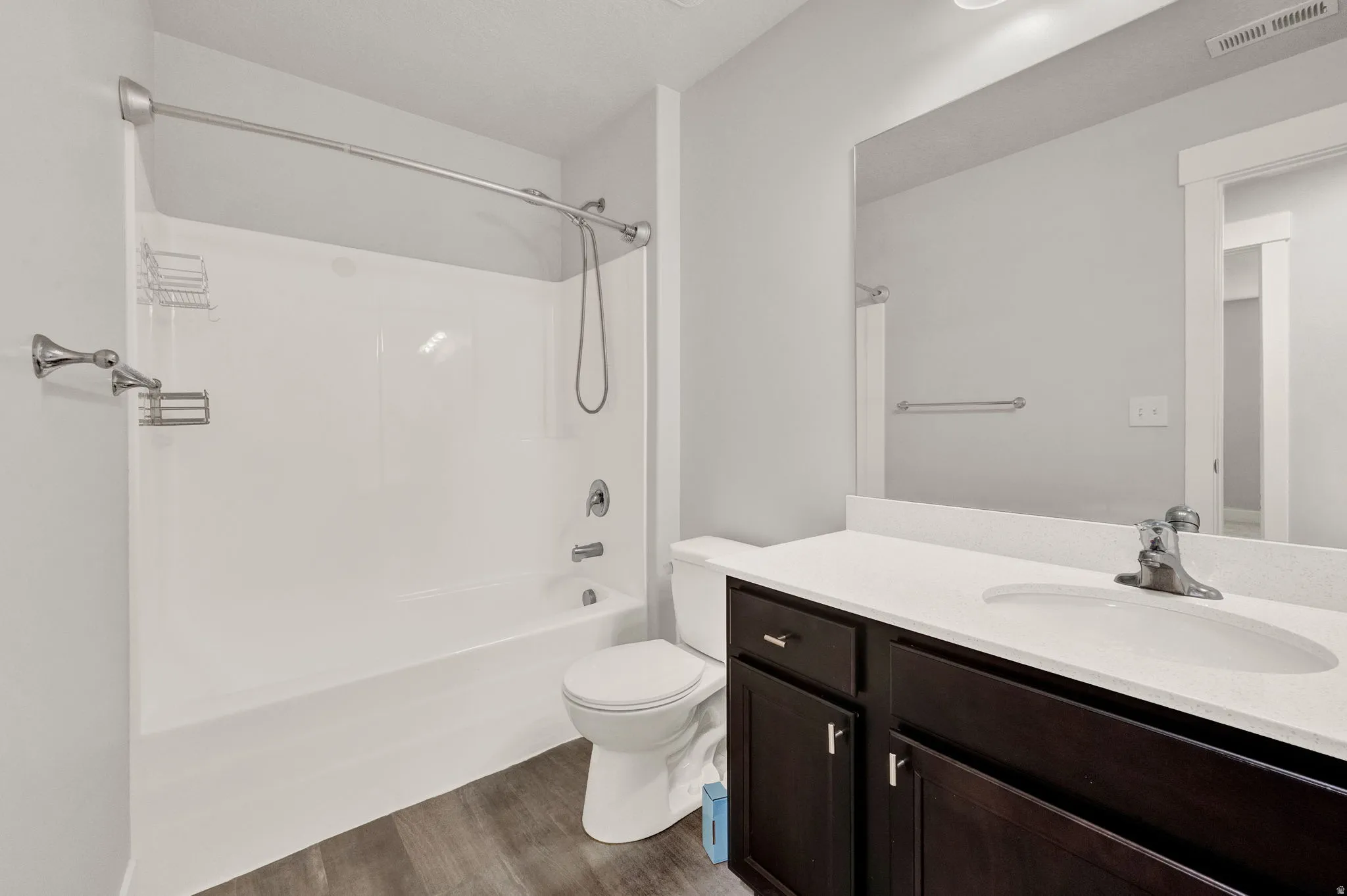 White bathtub and shower combination with chrome fixtures