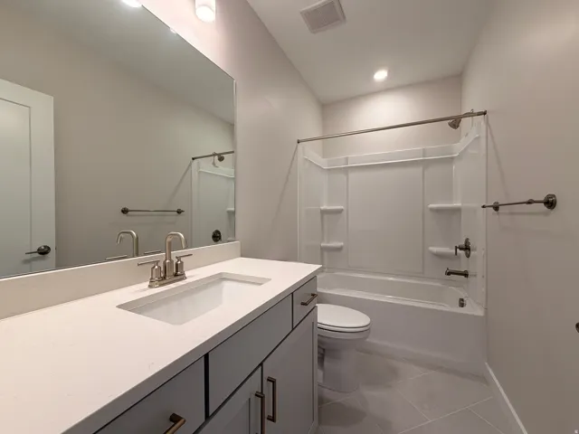Bathroom featuring a white integrated sink, light-toned countertop, and a vanity with bronze-toned hardware