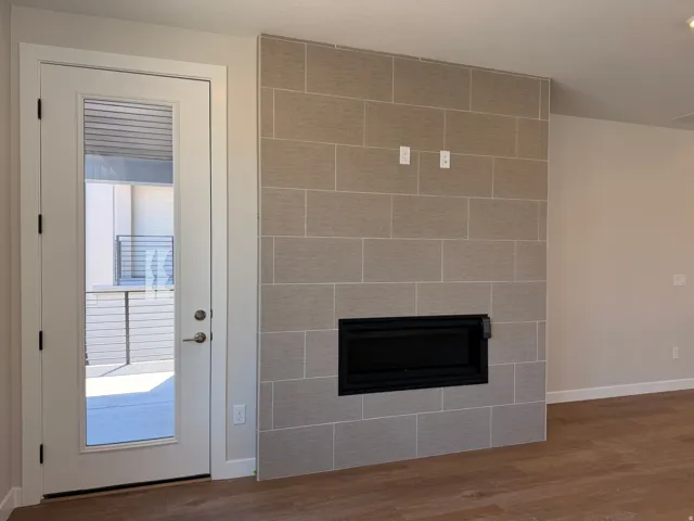 Tiled feature wall with an integrated fireplace and wood-finish flooring