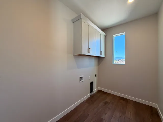Dedicated laundry space featuring rich wood-finish flooring