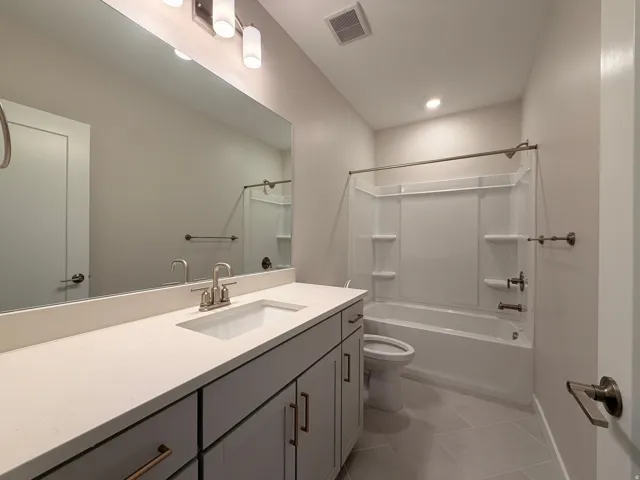 Bathroom featuring a single vanity with light grey cabinetry, a drop-in sink, and a light-colored countertop
