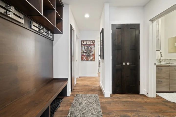 Entryway featuring wood-finish flooring and a built-in bench with integrated shelving