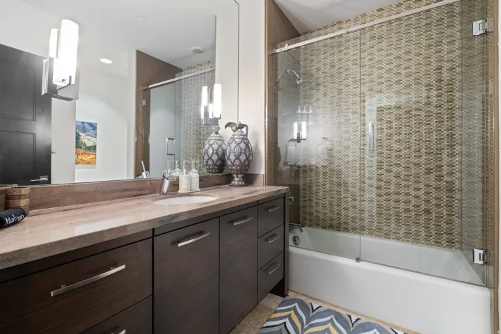 Spacious vanity with a light brown countertop, undermount sink, and dark wood-finish cabinetry