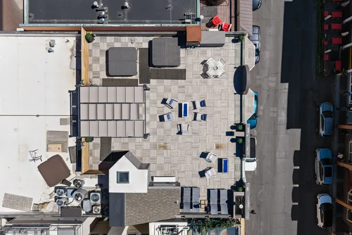 Spacious rooftop terrace featuring paver flooring, multiple seating areas, a hot tub, and a pergola