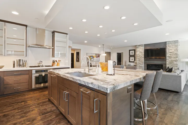 Open-concept interior featuring a substantial kitchen island with an integrated sink and stone countertop
