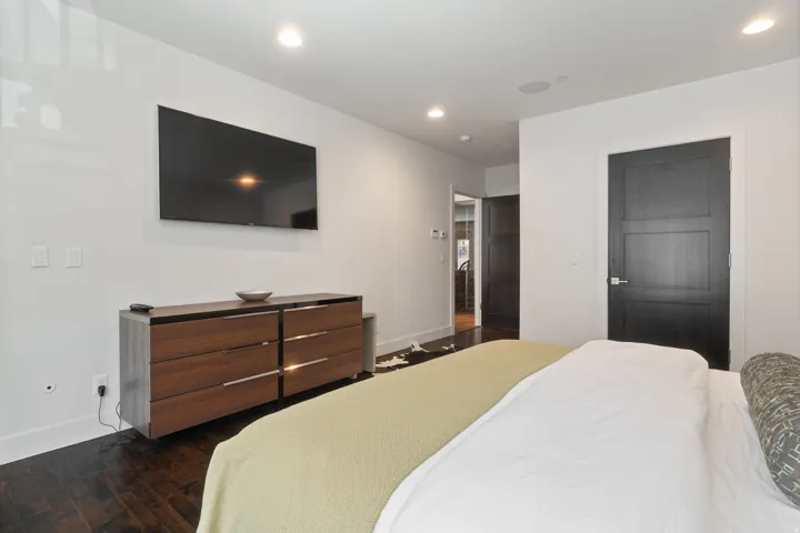 Recessed lighting illuminating dark wood-finish flooring