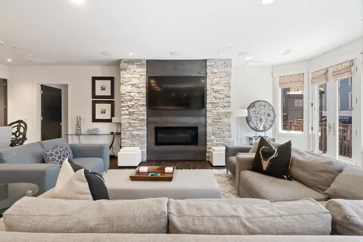 Living area featuring a stone accent wall, integrated fireplace, and recessed lighting