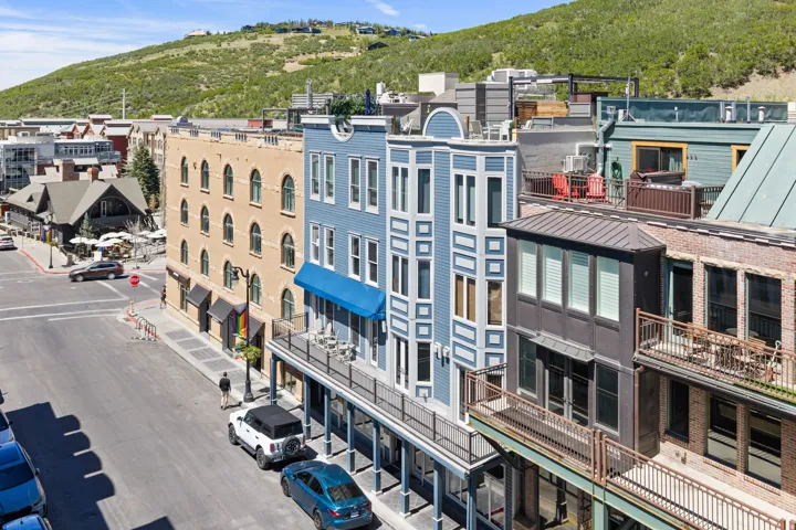 Historic Main Street architecture featuring a light blue building with white trim, a projecting bay window, and a ground-floor balcony