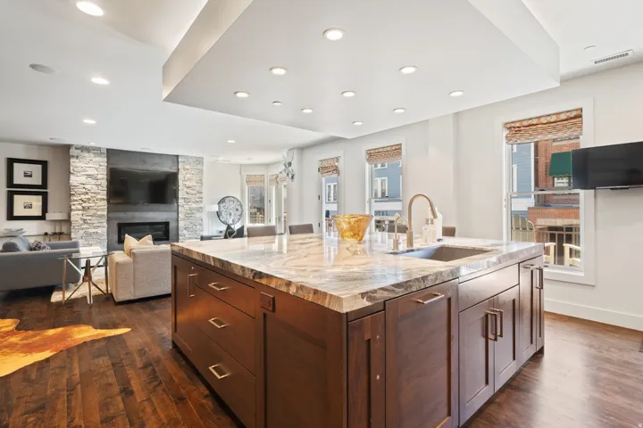 Spacious kitchen island featuring a stone countertop, integrated sink, and ample cabinetry