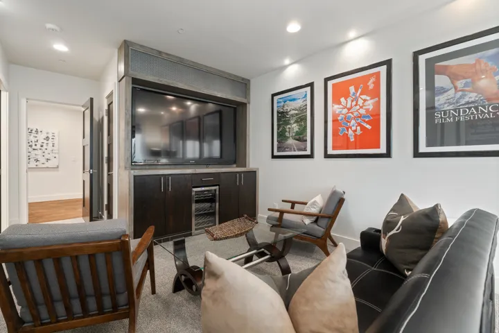 Media room featuring a built-in entertainment center with a wine cooler, recessed lighting, and light-toned carpeting