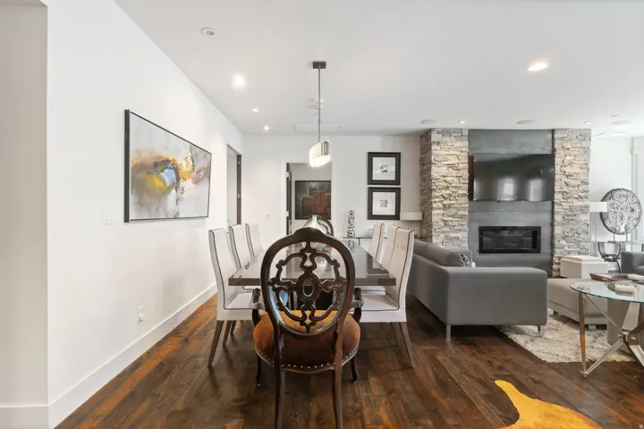 Open-concept dining area featuring wood-finish flooring, recessed lighting, and a modern pendant fixture