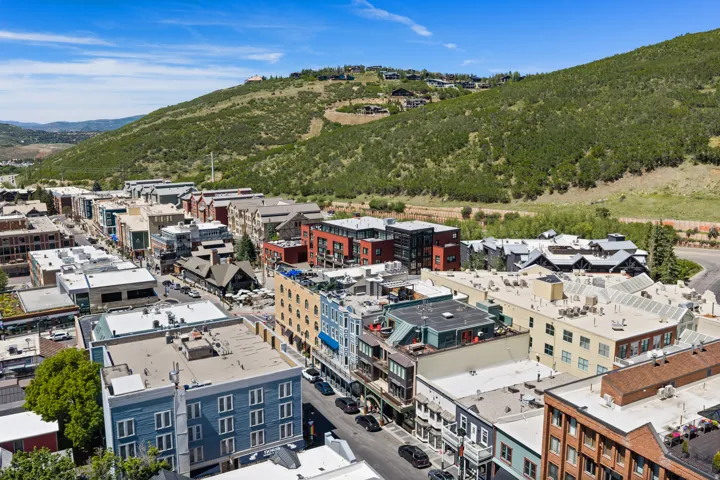 Aerial perspective showcasing a vibrant urban streetscape nestled against a verdant hillside