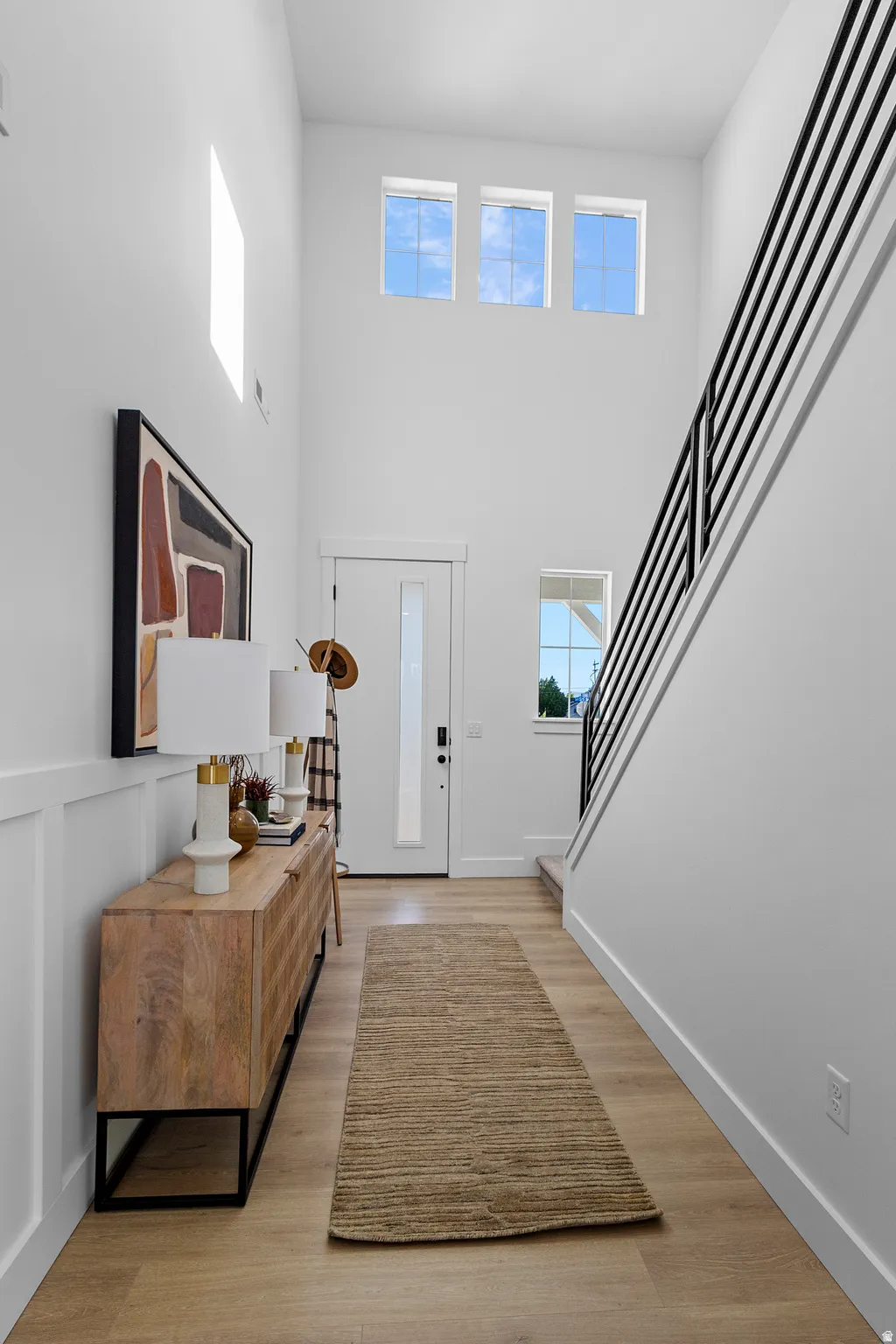 Two-story entryway featuring high ceilings and wood-finish flooring (PICTURE IS FROM A PREVIOUS HOME...COLORS AND FINISHES MAY BE DIFFERENT)