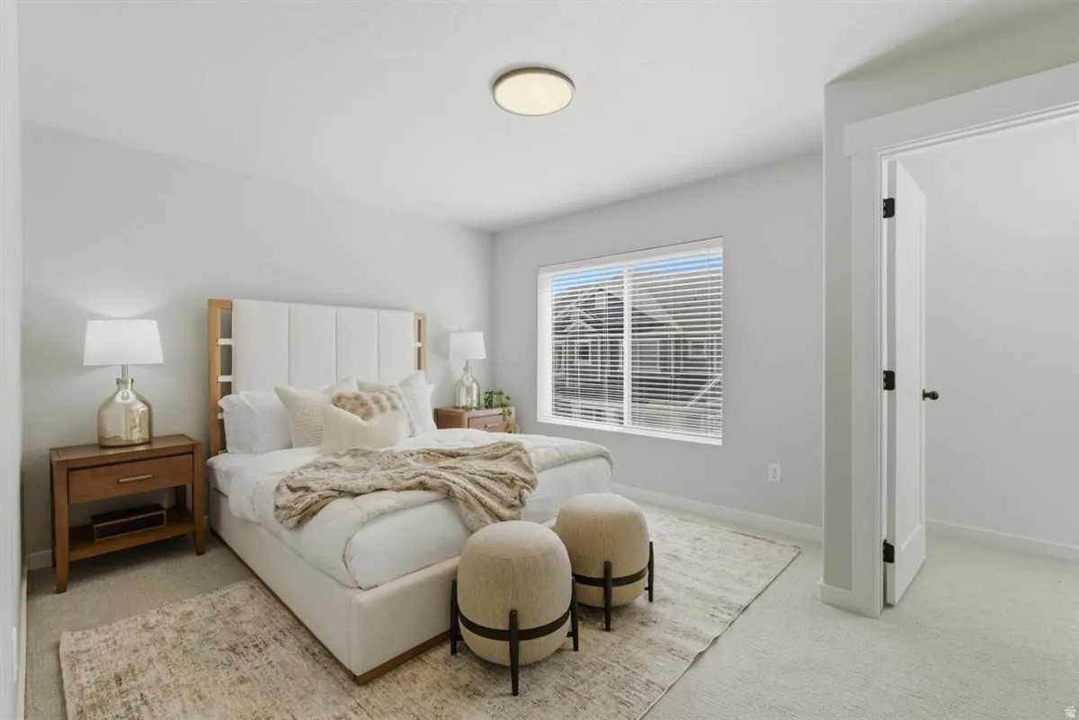 Carpeted bedroom with a window featuring horizontal blinds