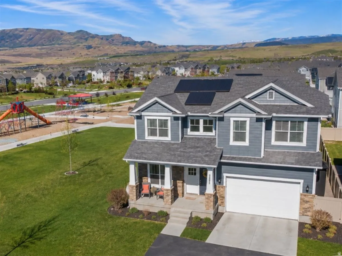 Two-story residence featuring a covered front porch, stone accents, and an attached two-car garage