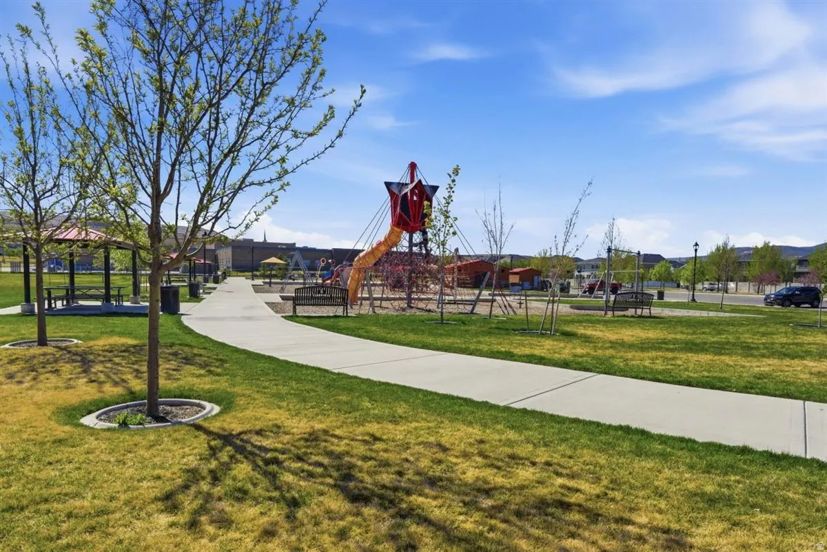 Expansive green space featuring a playground with slides, swings, and climbing structures