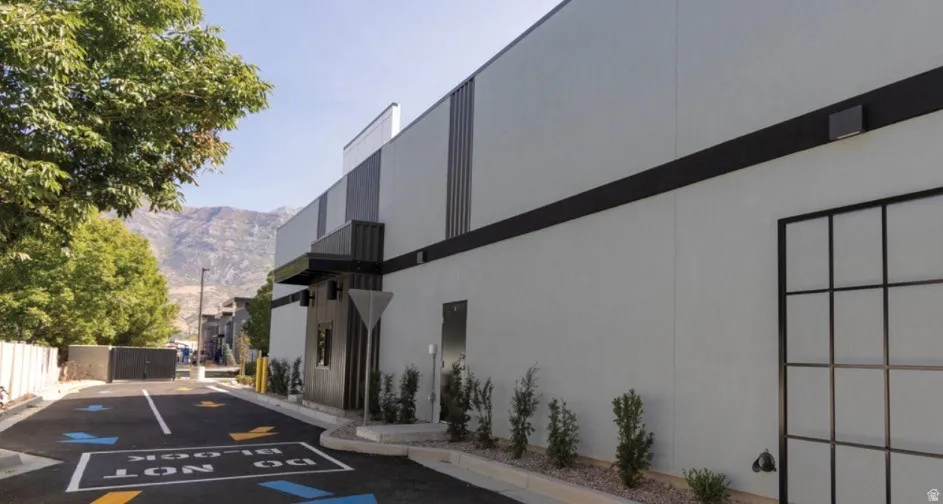 Contemporary commercial building featuring a light gray exterior with dark trim and vertical accents
