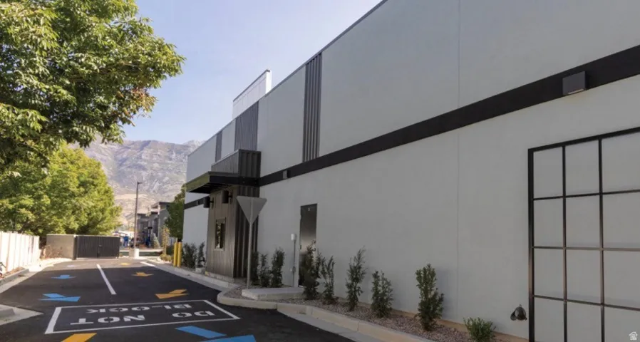 Contemporary commercial building featuring a light gray exterior with dark trim and vertical accents