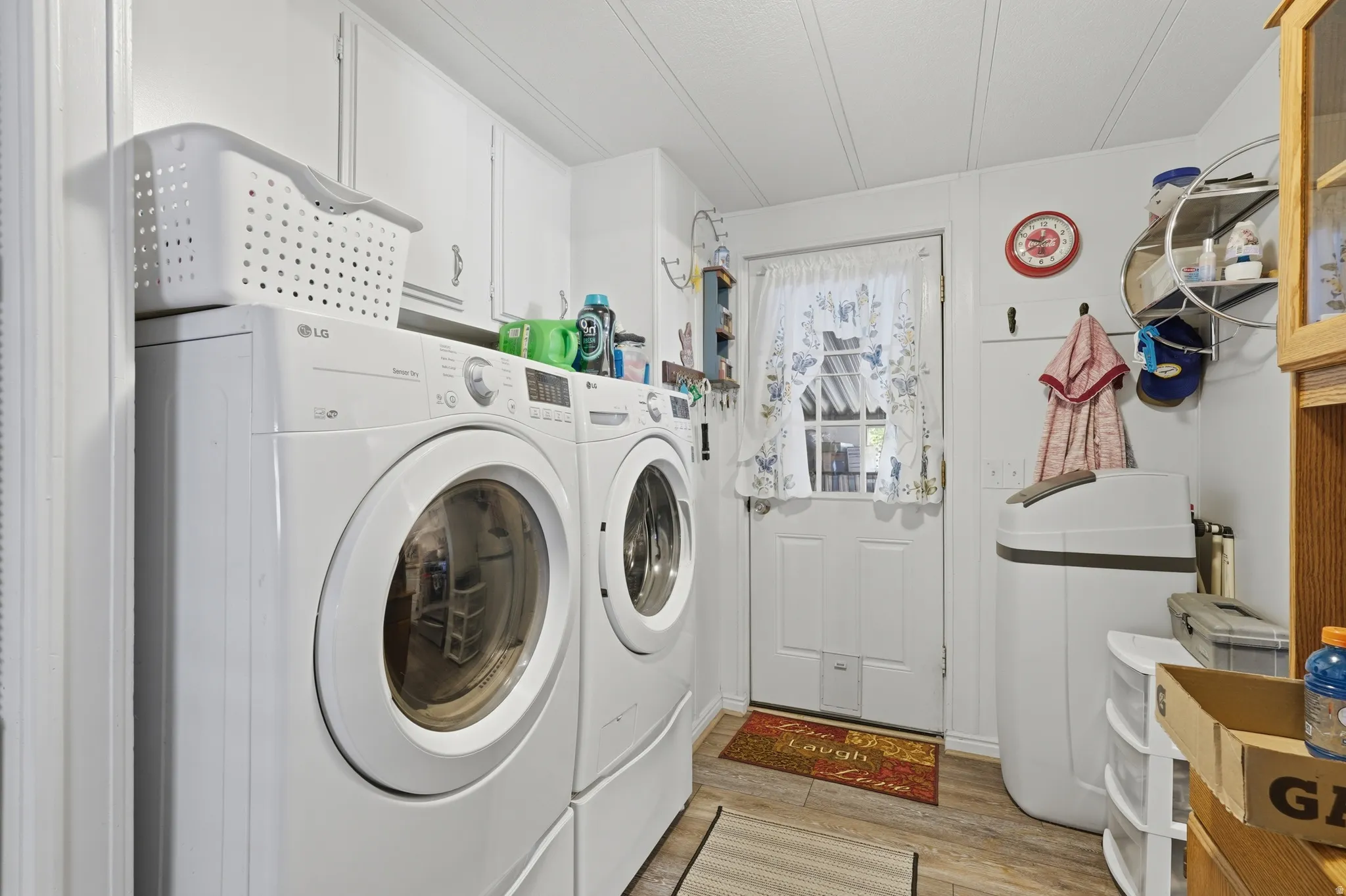 Laundry area featuring wood-finish flooring, white paneled walls, and a white beadboard ceiling