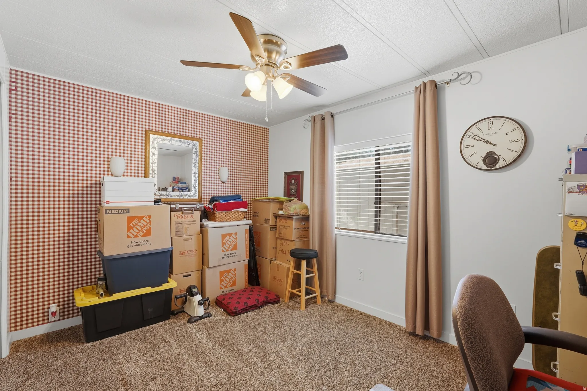 Carpeted room with a ceiling fan, window with blinds, and red gingham patterned wall