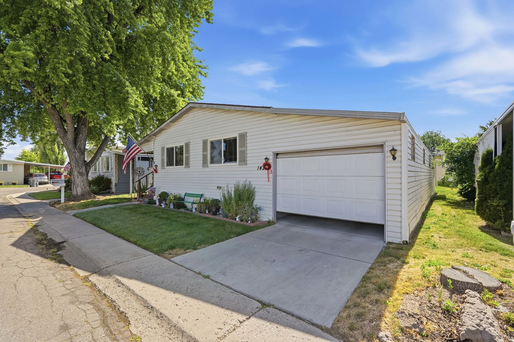 Single-story residence featuring white vinyl siding, a front-facing garage with a white panel door, and a concrete driveway