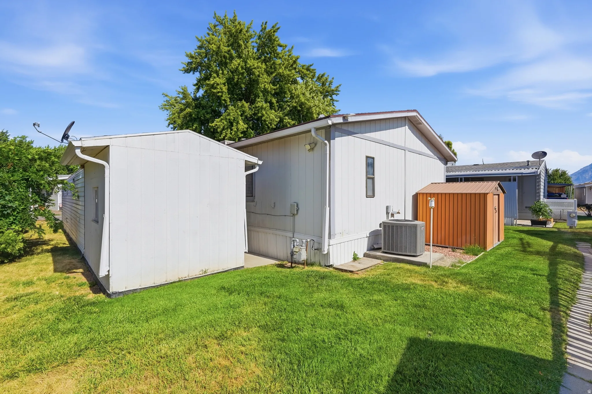 Manicured green lawn with an exterior HVAC unit on a concrete pad