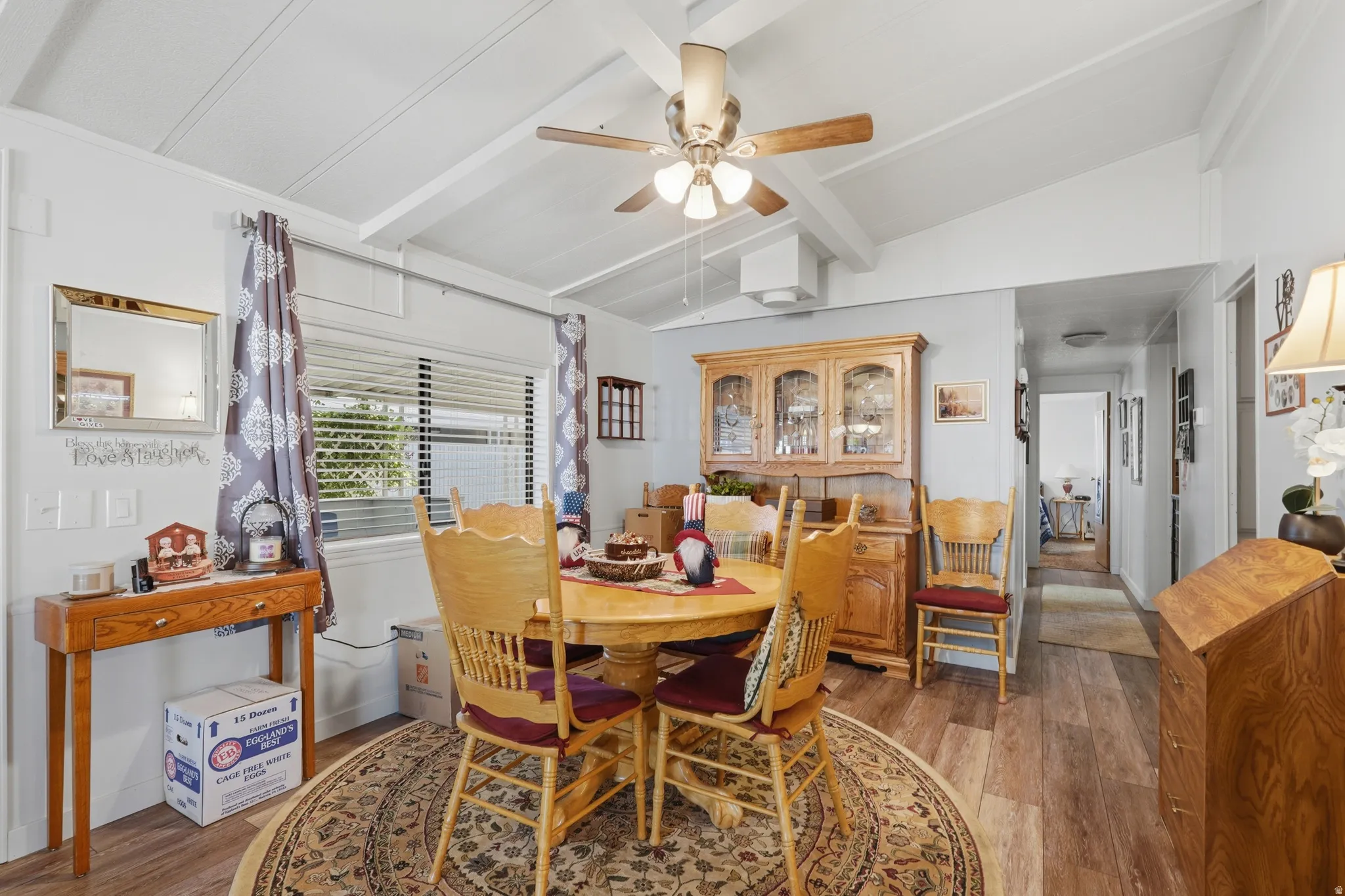 Vaulted ceiling with exposed beams, wood-finish flooring, and built-in hutch cabinetry