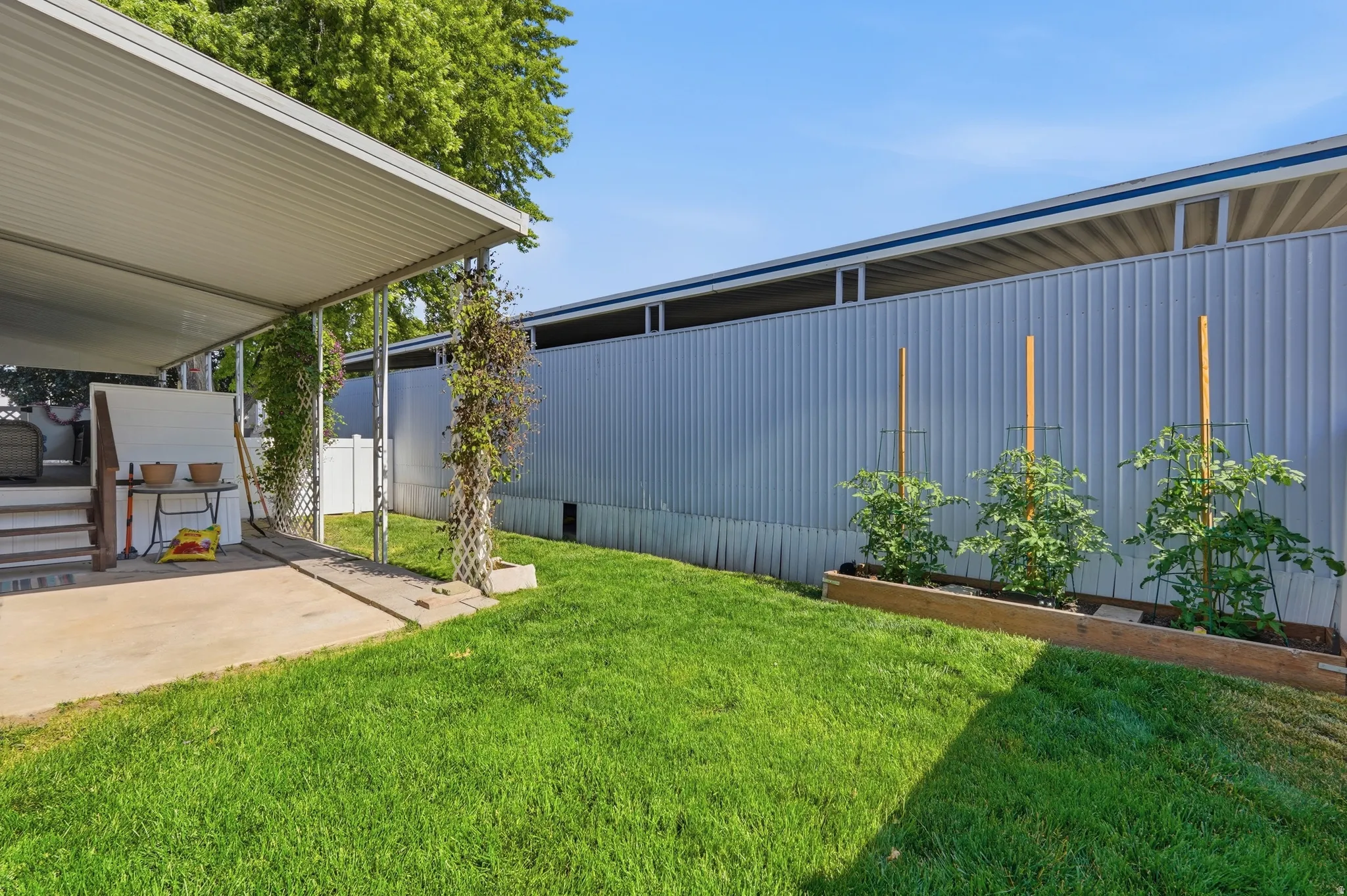 Exterior patio with a covered awning, concrete flooring, and steps leading to an elevated platform