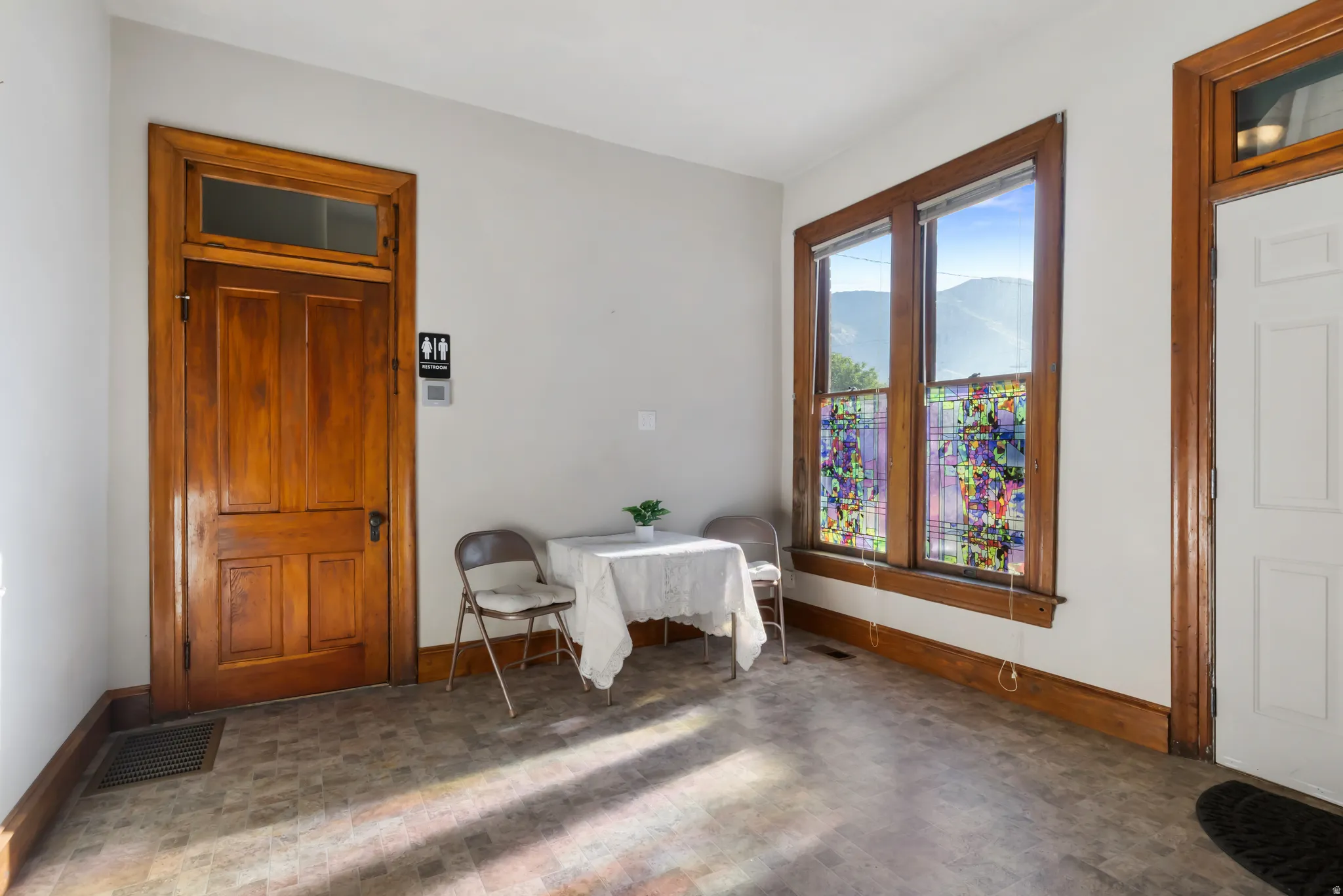 Interior space featuring multiple windows with mountain scenery, a paneled wood door with transom, and wood trim detailing throughout